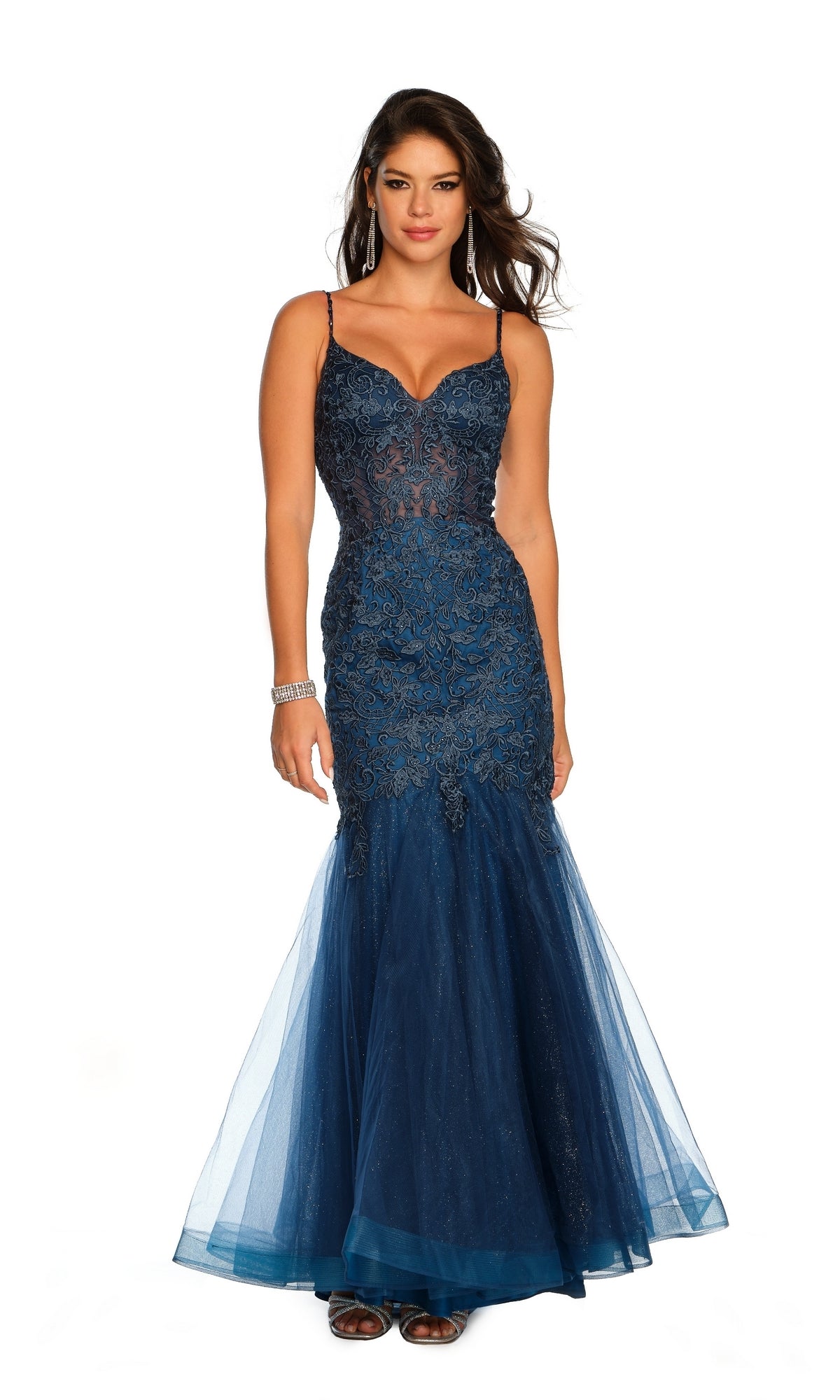A woman poses gracefully in the Dave & Johnny A10625 Long Lace Mermaid Prom Dress, a navy blue gown with spaghetti straps and intricate embroidered lace, set against a plain white background.